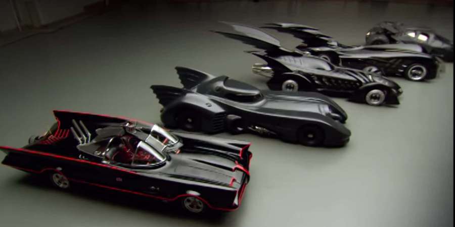 Four Batmobiles from Batman movies displayed in a garage. — Batmobile Background