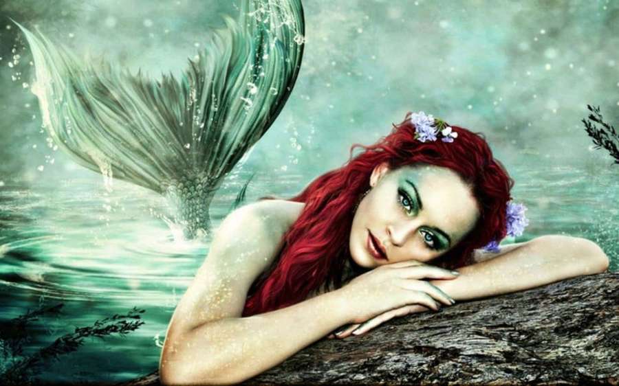 A mermaid with red hair and green tail rests on a log in glowing turquoise water. — Beautiful Mermaid Wallpaper