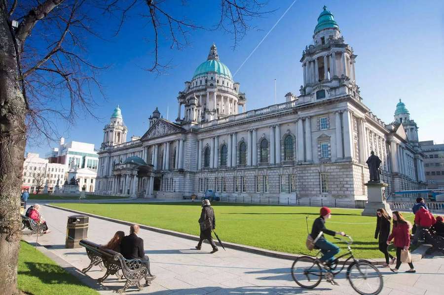 People walking and cycling near Belfast City Hall on a sunny day. — Belfast Wallpaper