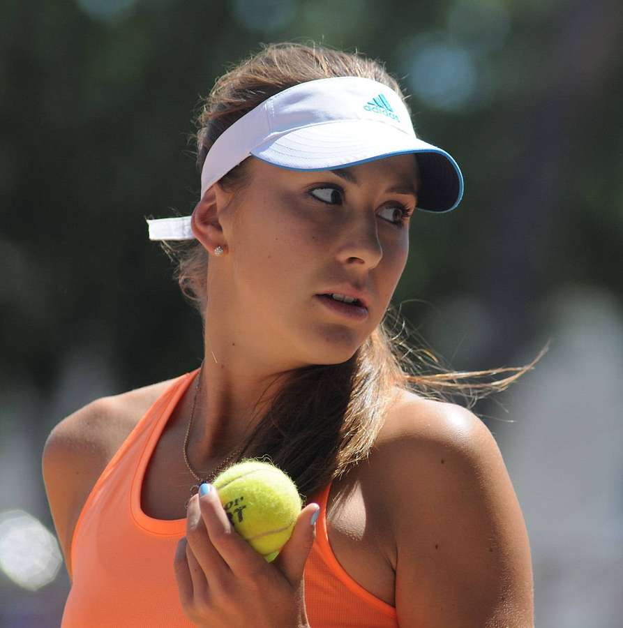 Tennis player in orange top holding yellow ball outdoors in bright sunlight. — Belinda Bencic Wallpaper