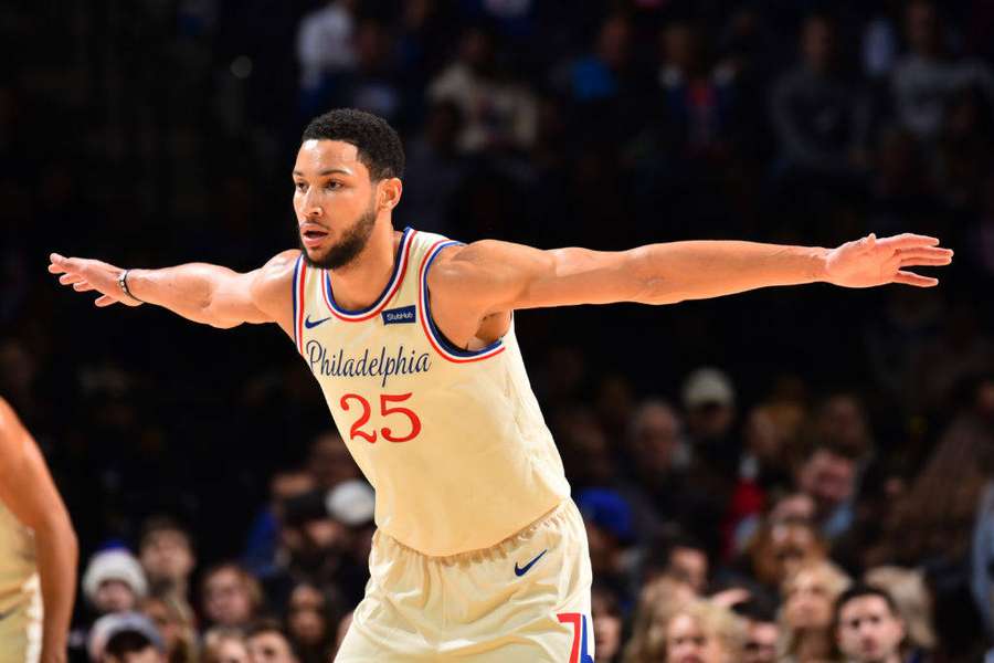 Professional basketball player in cream jersey with arms outstretched during game. — Ben Simmons Background