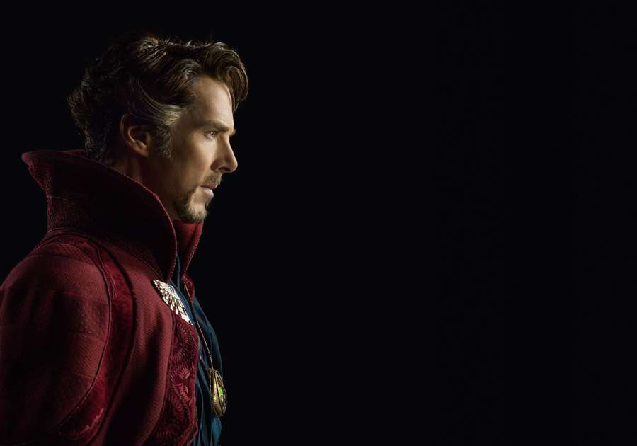 Man in red robe with gold medallions looking right against black background. — Benedict Wallpaper