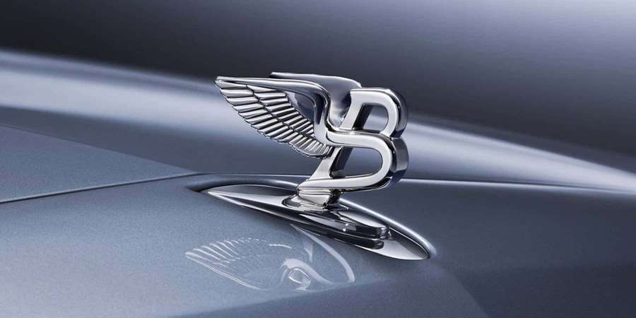 Chrom-Bentley-Logo auf einer Luxusauto-Motorhaube mit metallisch blauem Finish und Reflexion. — Bentley Bilder