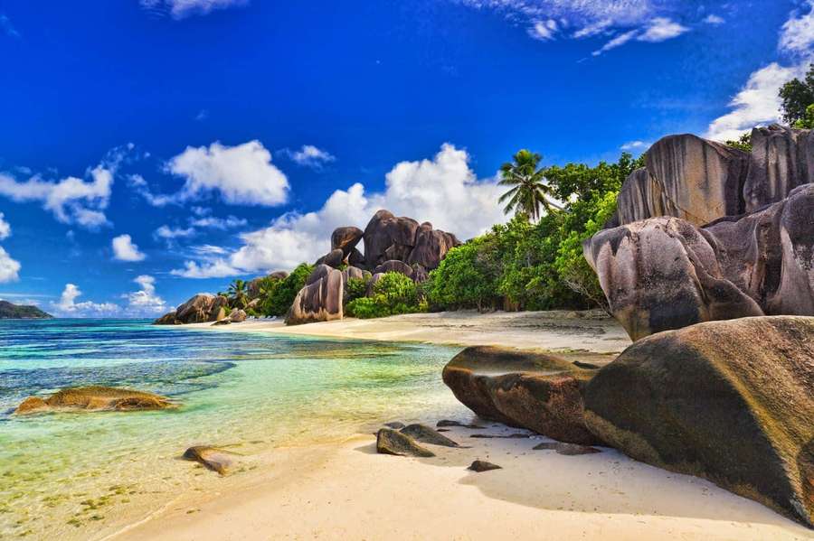Tropical beach with turquoise water white sand and giant boulders under a bright blue sky. — Best Beach Background