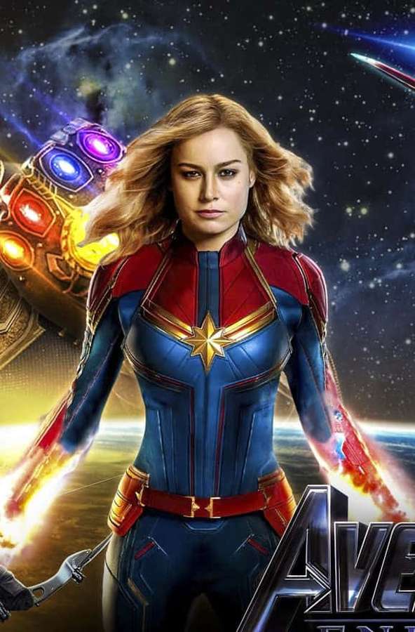Captain Marvel in her blue and red suit with energy blasts and infinity gauntlet in space. — Best Captain Marvel Background
