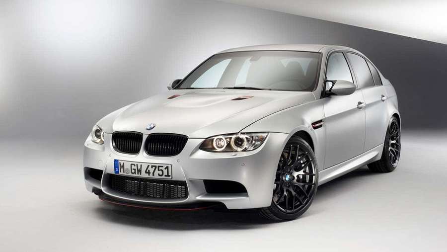 Silver BMW M3 sedan with black rims and red trim in studio lighting. — Best M Series Background