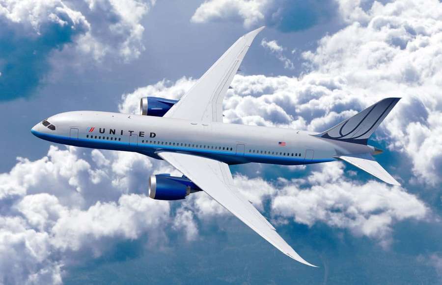 United Airlines jet flying through clouds on a clear day. — Best Plane Background
