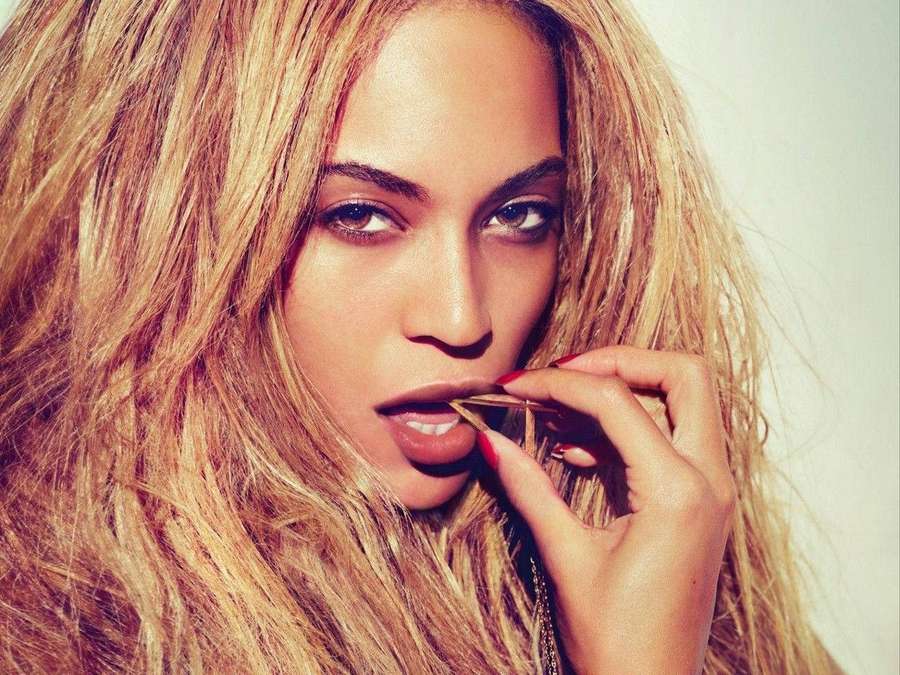 Beyonce aplicando lápiz labial con mirada intensa y cabello dorado. — Beyonce Fondos de pantalla