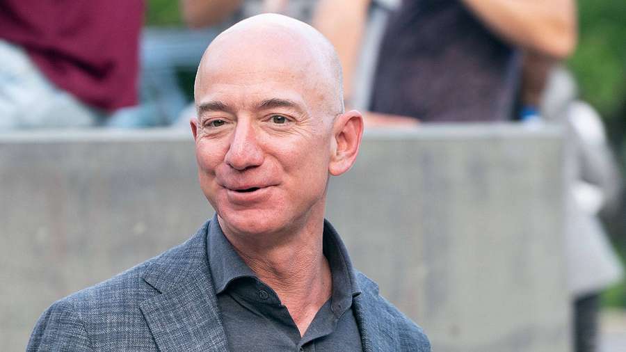 Bald man in gray suit smiling outdoors in daylight — Bezos Background