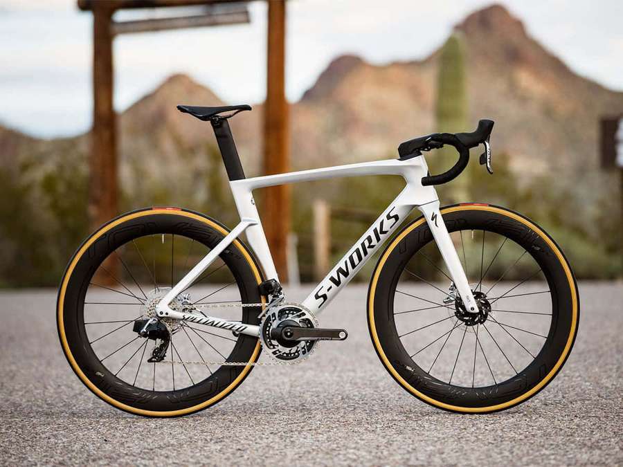 White Specialized S-Works road bike with gold tires parked in a desert landscape. — Bicycle Background