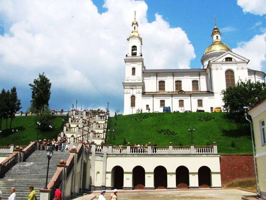 Igreja branca com cúpulas douradas em uma colina acessada por escadaria de pedra com pessoas andando. — Bielorrússia Papéis de Parede