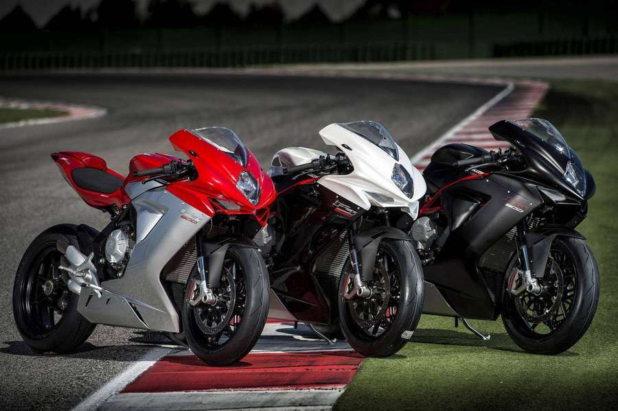 Three sport motorcycles parked on a racetrack curb. — Bikes Picture