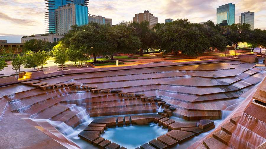 Stadtbrunnen mit kaskadierendem Wasser und Skyline bei Sonnenuntergang. — Bilder Von Fort Wallpaper