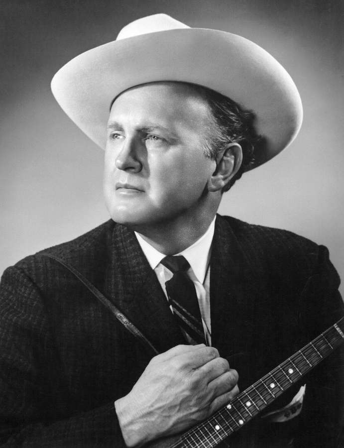 Mann mit Cowboyhut, der Gitarre hält, in schwarz-weißem Studio-Porträt. — Bill Monroe Bilder