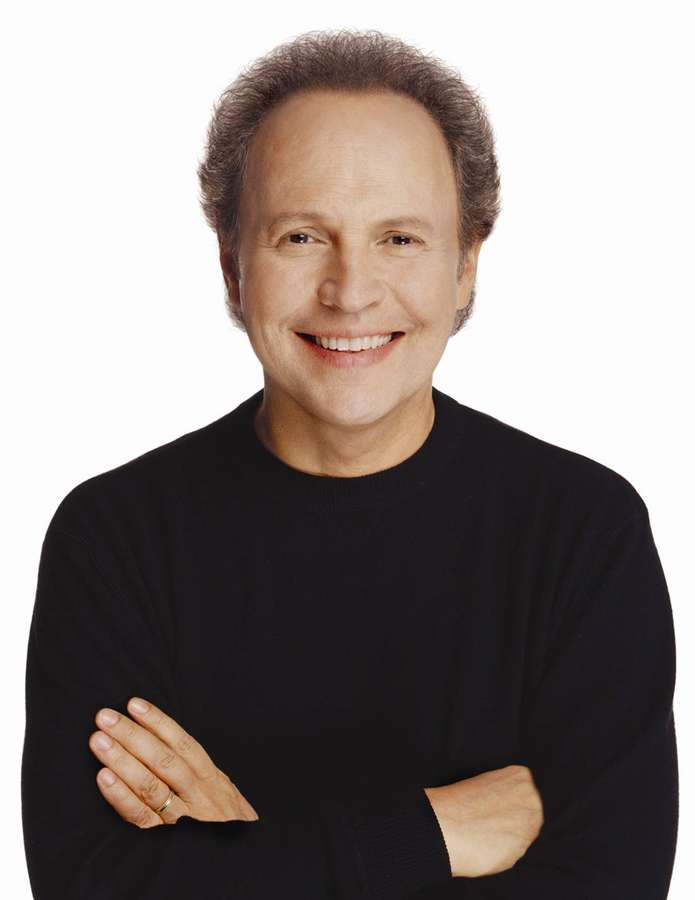A smiling man in a black sweater with arms crossed. — Billy Crystal Wallpaper