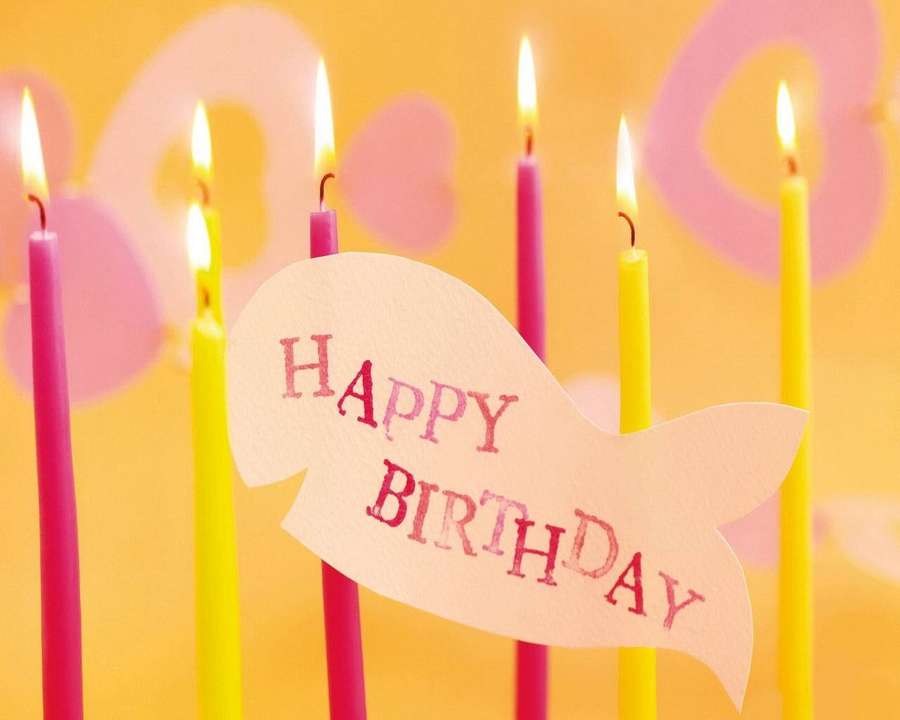 Happy Birthday card shaped like a fish with lit pink and yellow candles. — Birthday Background