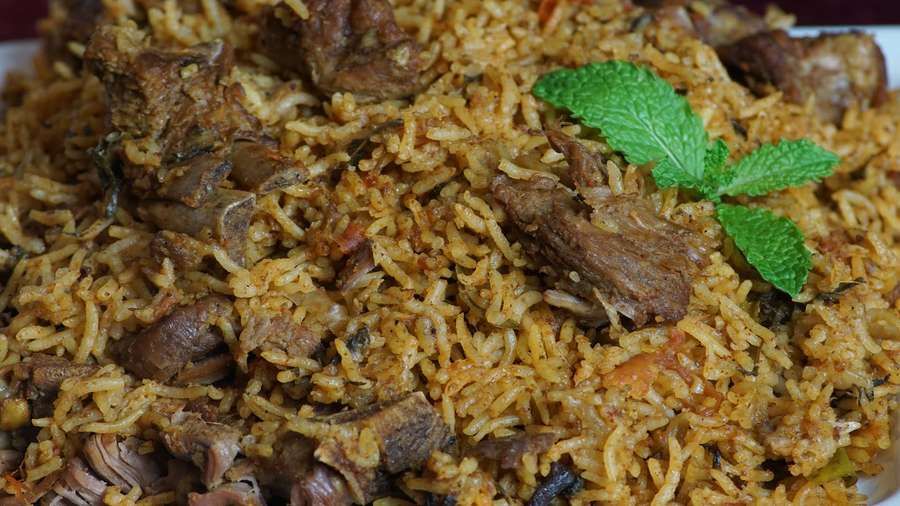 Ein Teller mit aromatischem Biryani-Reis mit Fleisch und Minzblättern. — Biryani Bilder