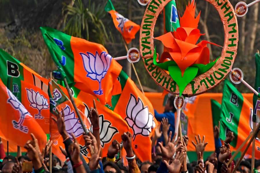 Menschen bei einer politischen Kundgebung, die BJP-Parteiflaggen schwenken und ein Lotus-Symbol halten. — Bjp Bilder