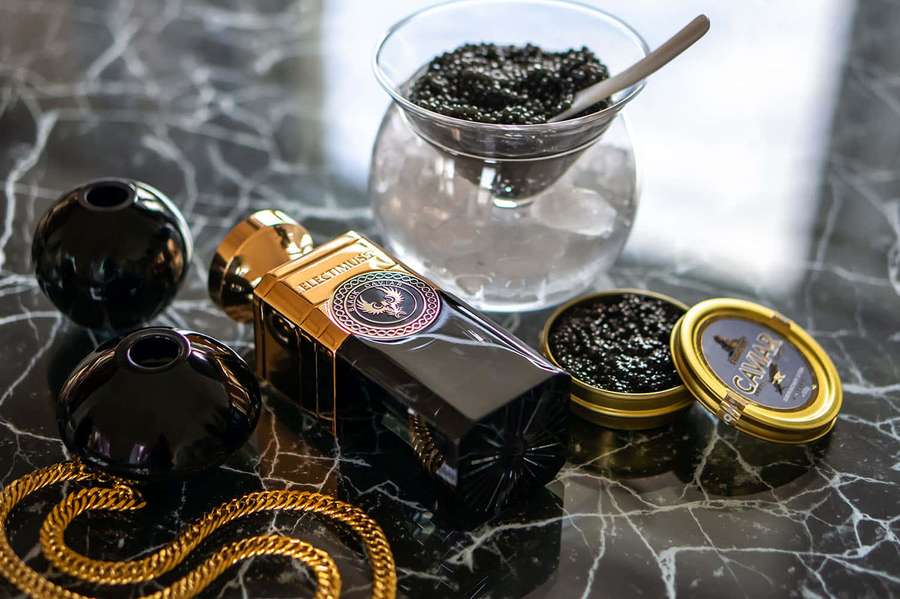 Black caviar and gold jewelry on a marble countertop. — Black Caviar Wallpaper