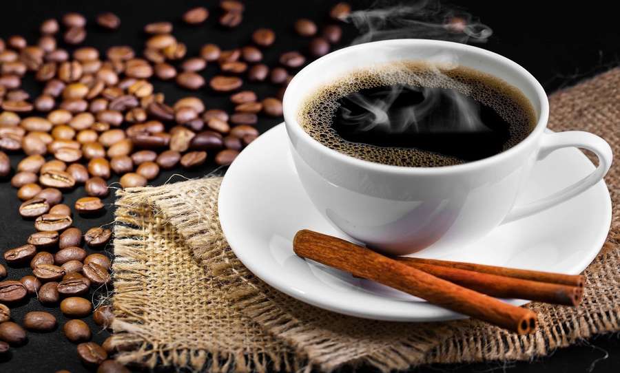 Steaming cup of coffee with cinnamon sticks and scattered beans on burlap. — Black Coffee Wallpaper