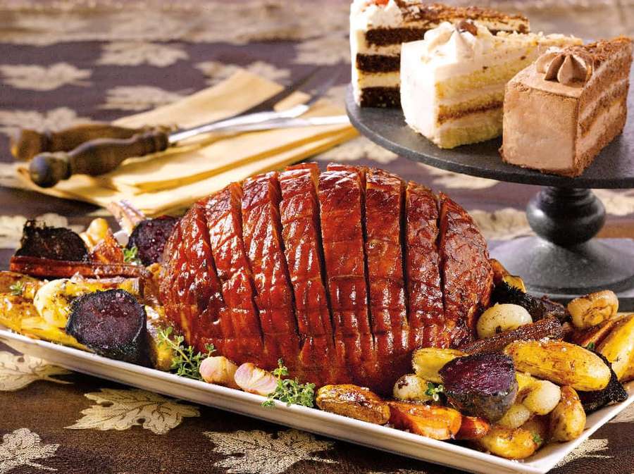 Roasted ham with roasted vegetables and dessert on a festive table. — Black Forest Ham Wallpaper