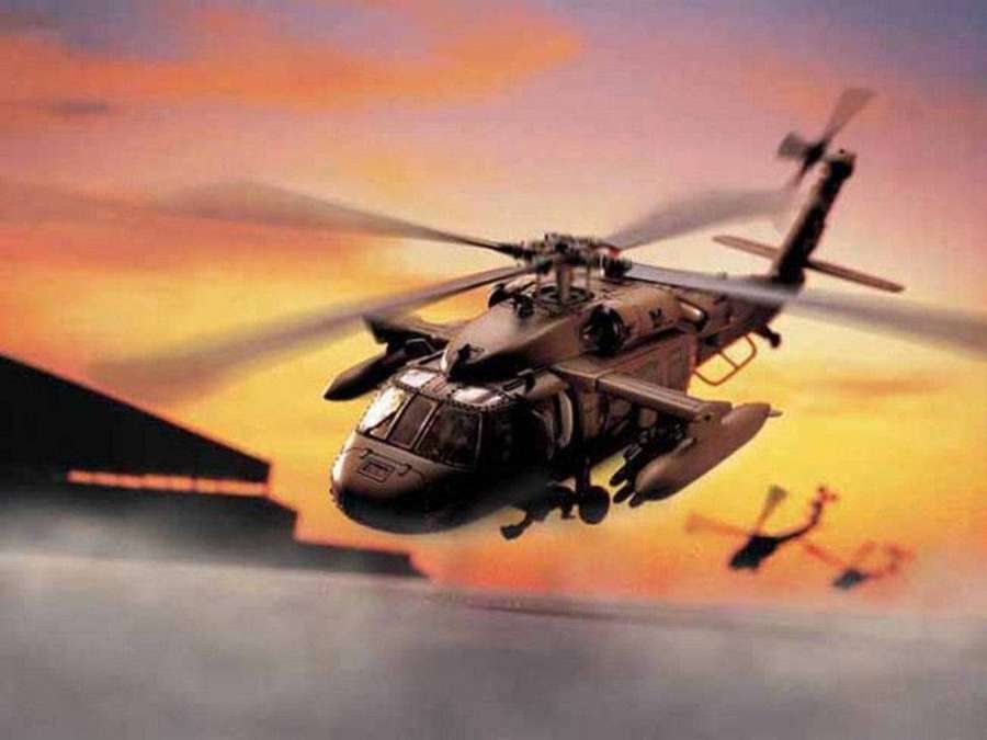 Militärhubschrauber fliegt bei Sonnenuntergang mit einem weiteren Hubschrauber im Hintergrund. — Black Hawk Hubschrauber Wallpaper