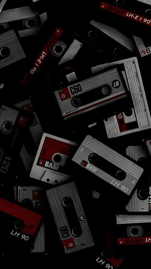 Vintage BASF cassette tapes scattered on a dark background. — Black Retro Wallpaper