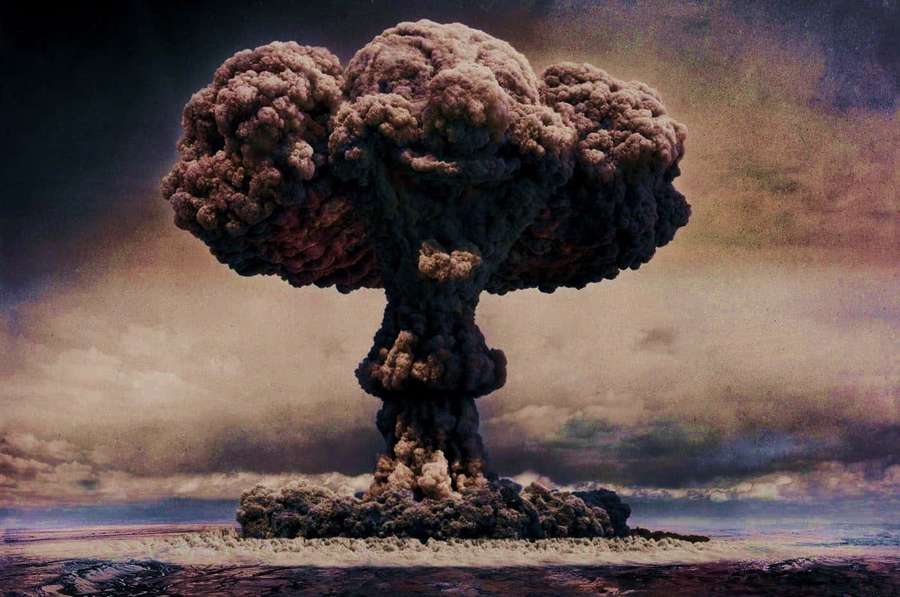 Eine Pilzwolke einer Atomexplosion steigt über einer kargen Landschaft auf. — Blast Hintergrundbild