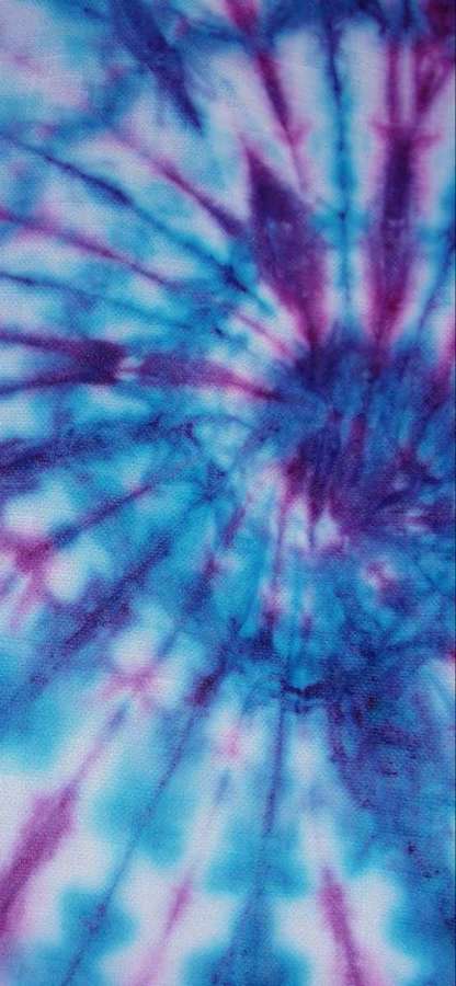 Nahaufnahme von blauem und lila Batikstoff mit Sternenexplosionsmuster. — Blaue Batikfarbe Hintergrundbild