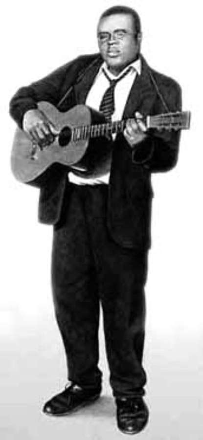 Mann i dress spiller akustisk gitar i studio — Blind Lemon Jefferson Bakgrunner