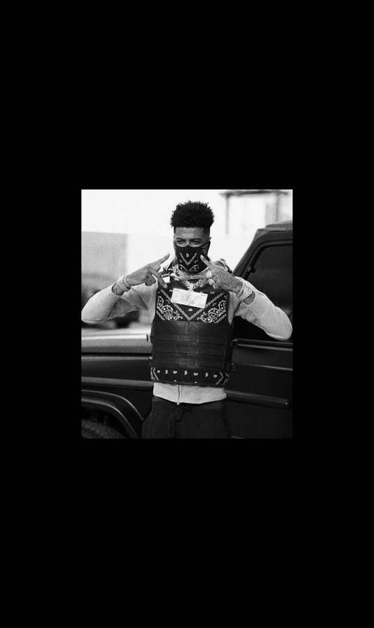 Mann mit Stirnband und Weste posiert neben einem Fahrzeug in schwarz-weißer urbaner Umgebung. — Blueface Bilder Hintergrund Wallpaper