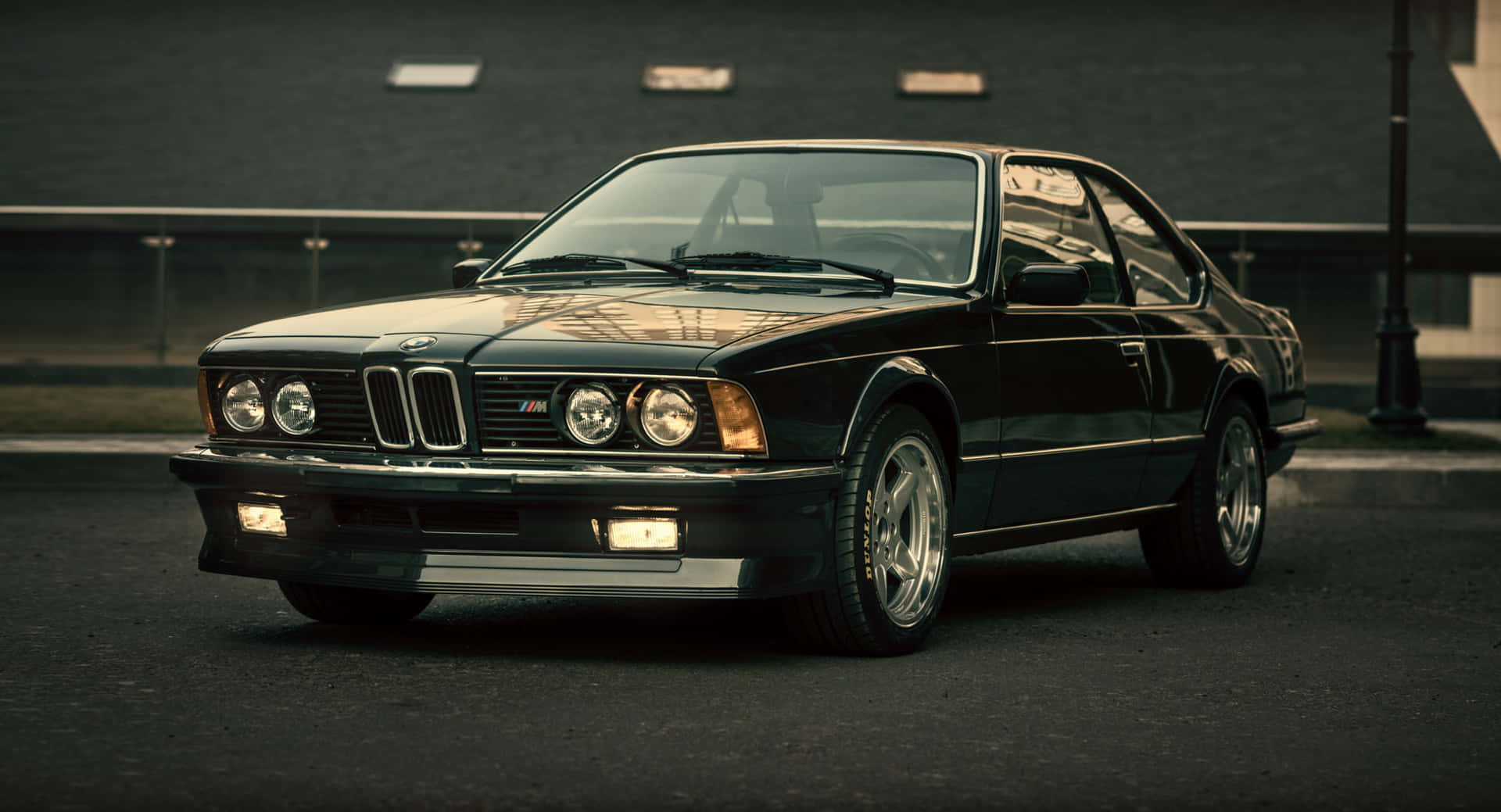 Classic black BMW M6 sports car parked on city street at dusk. — Bmw Android Picture