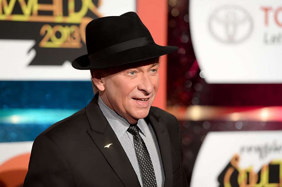 Man in black fedora and suit smiling at awards ceremony. — Bobby Caldwell Wallpaper