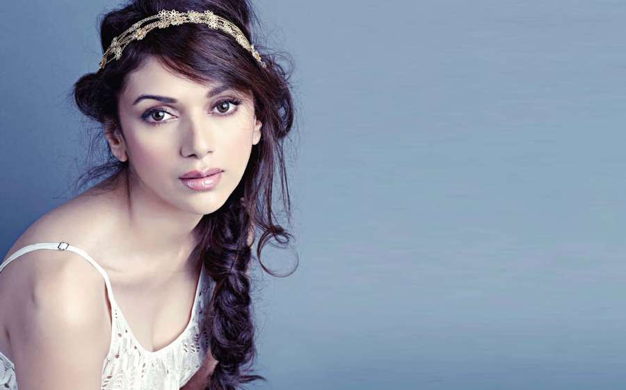 Woman with dark hair and gold headband looking at viewer in studio — Bollywood Background