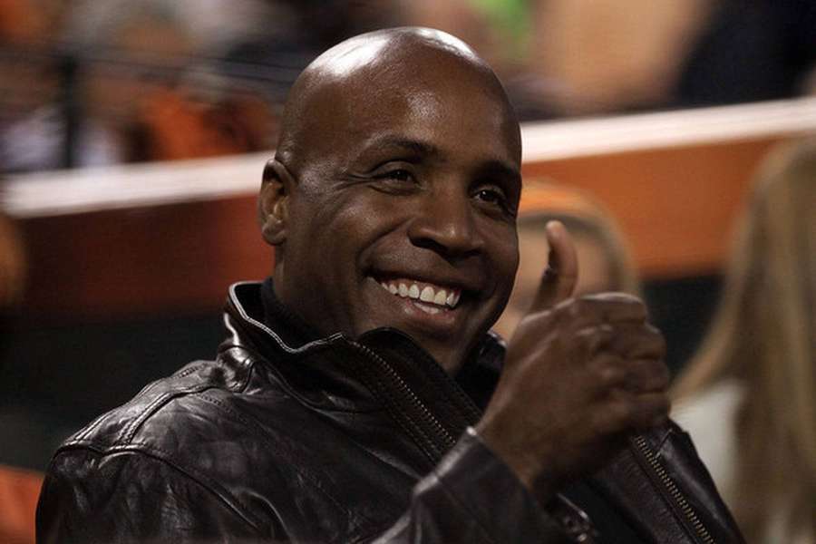 A smiling man in a black leather jacket gives a thumbs up gesture. — Bonds Background