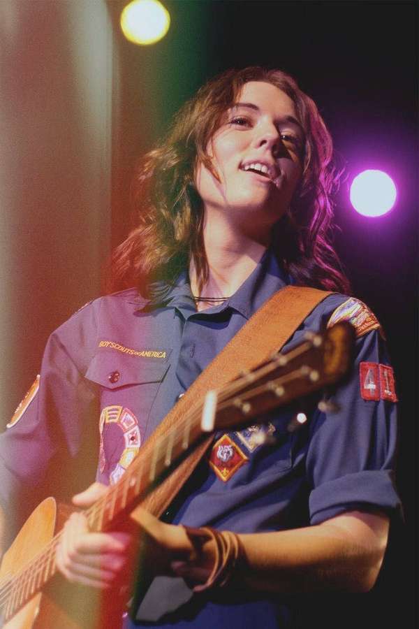 Musician playing guitar on stage under colorful lights — Brandi Wallpaper