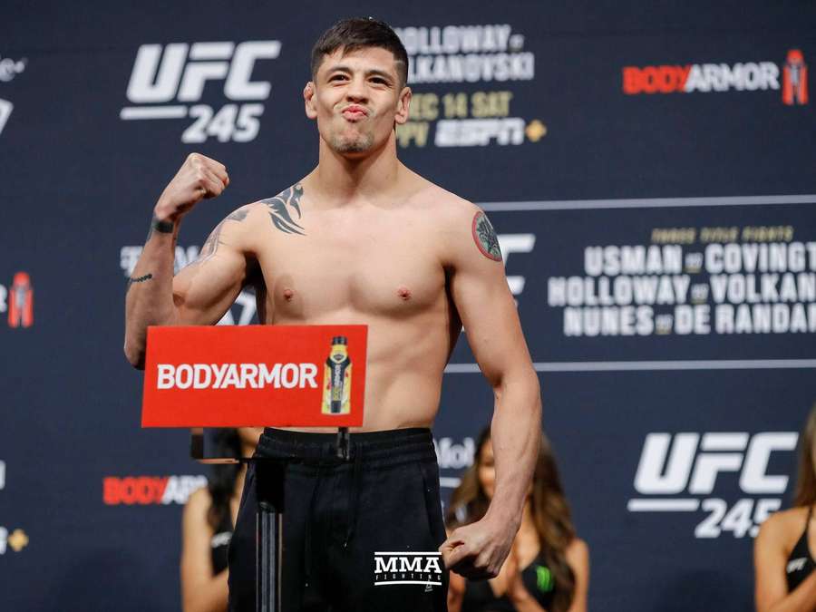 UFC fighter posing shirtless at weigh-in with BodyArmor sign — Brandon Moreno Wallpaper