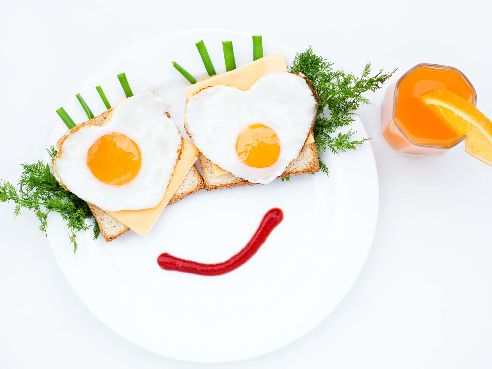 Leende ansikte gjort av hjärtformade stekta ägg, rostat bröd, ost och ketchup med apelsinjuice — Frukost bakgrund Bakgrundsbilder