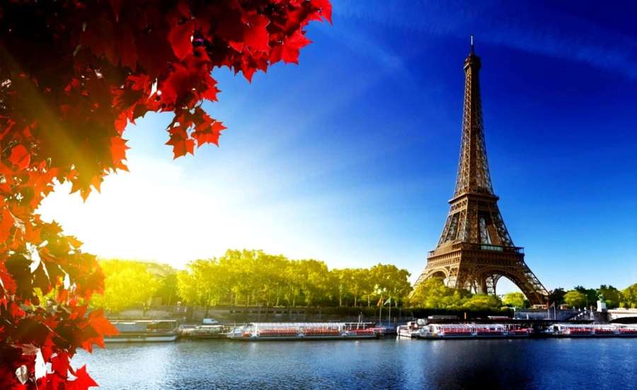 Eiffel Tower framed by red autumn leaves with boats on the Seine River at sunset. — Breathtaking Wallpaper