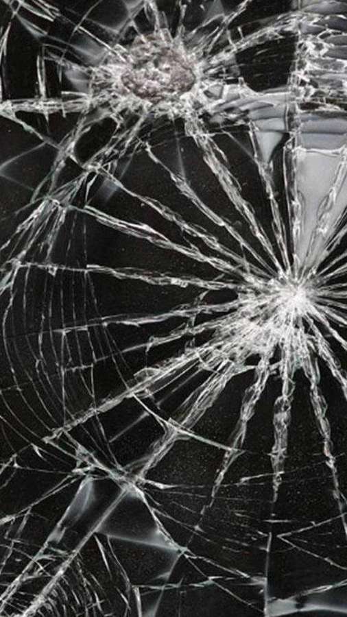 Close-up of cracked and broken glass with spiderweb fractures. — Broken Phone Background