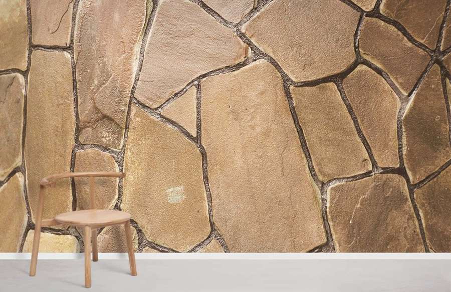 A simple wooden chair against a rustic stone wall in a modern room. — Brown Stone Wallpaper