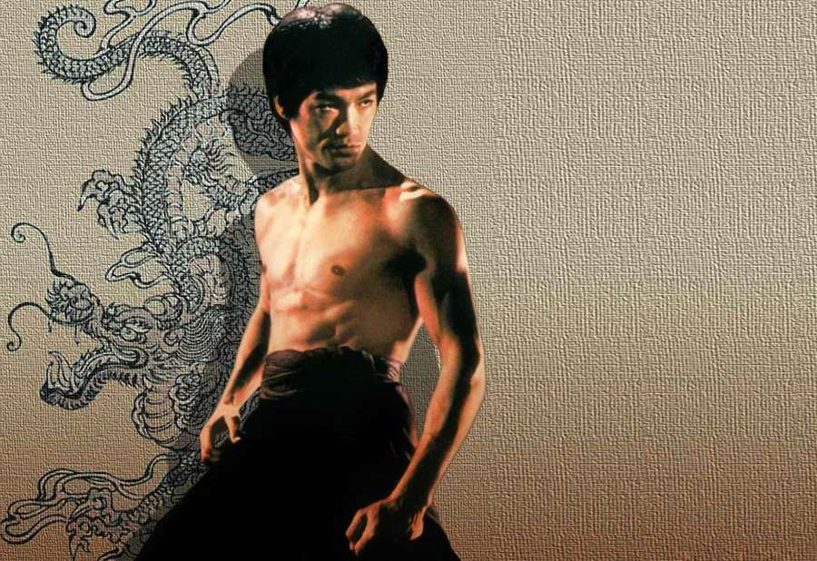 Bruce Lee in martial arts stance with dragon mural background — Bruce Lee Picture