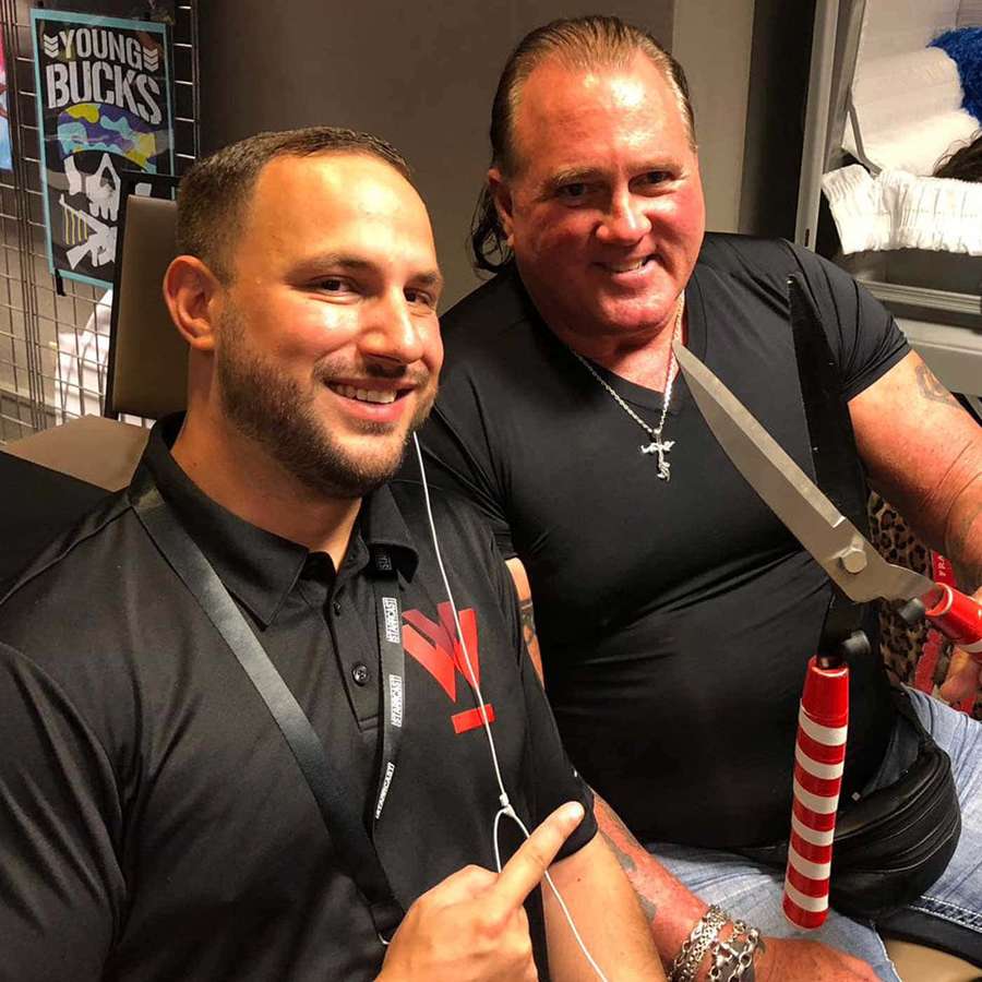 Two men smiling one holding giant scissors the other pointing at his arm. — Brutus Beefcake Wallpaper
