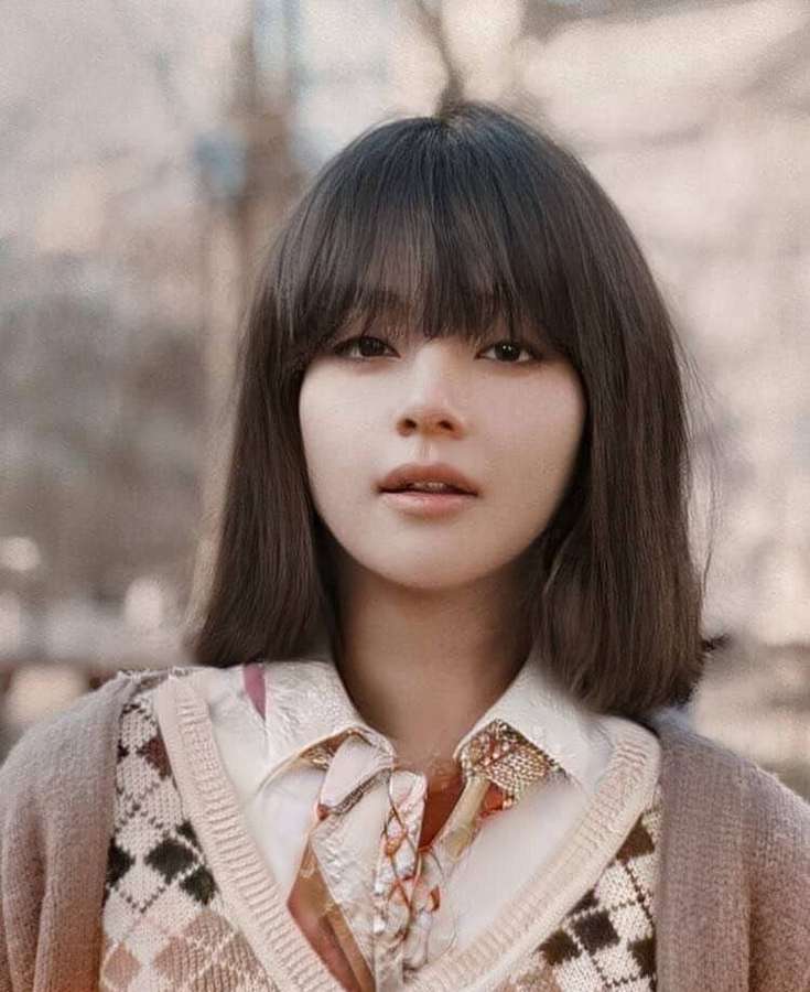 Young woman with dark bob hair wearing patterned sweater vest and floral blouse outdoors. — Bts Girls Wallpaper