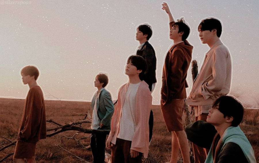 Seven young men in pastel clothing standing in a desert at twilight under a starry sky. — Bts Laptop Background