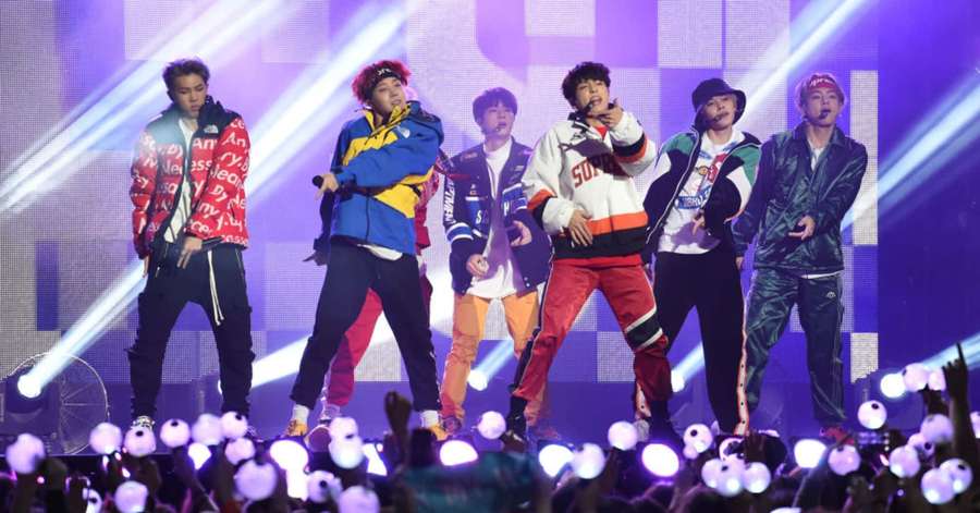 K-pop band performing live with fans holding glowing phones — Bts Live Wallpaper
