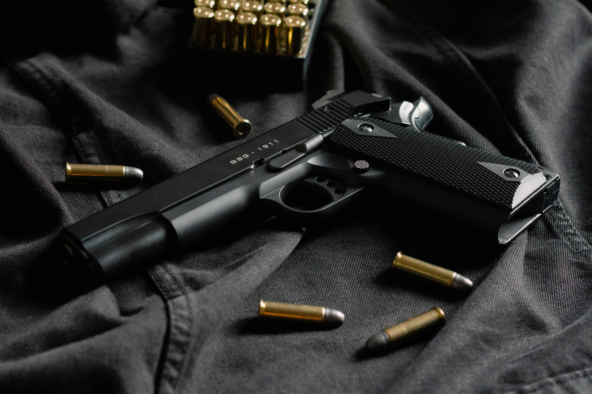 Svart pistol med mässingskulor på mörkt tyg — Bullet bakgrund Bakgrundsbilder