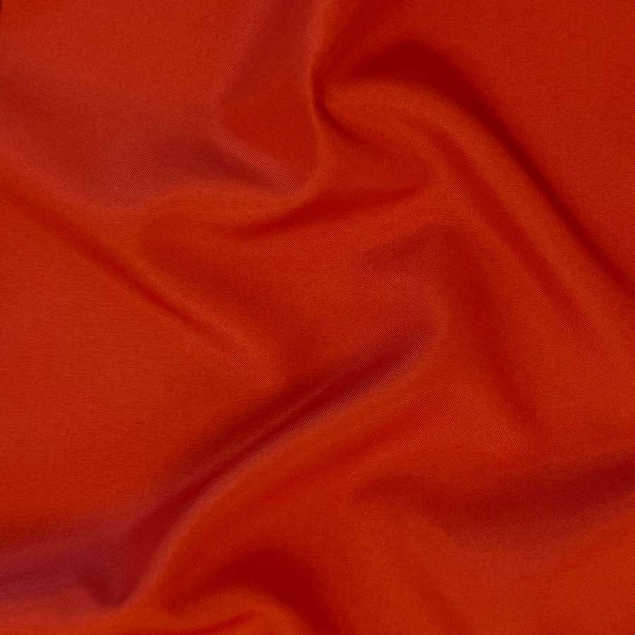 Close-up of crumpled crimson fabric with soft folds and subtle sheen. — Burnt Orange Background