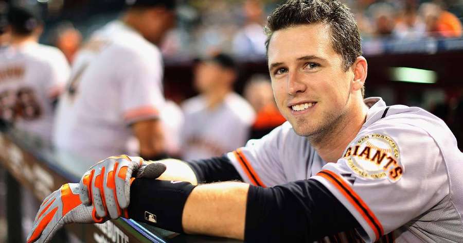 Baseball player in Giants uniform smiling in dugout — Buster Posey Background