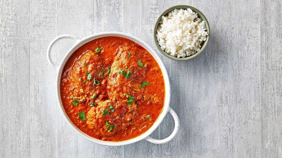 Eine Schale Hühnchen-Curry mit Reis auf einem Holztisch. — Butterhuhn Wallpaper